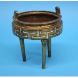 A bronze tripod censer with lion mask terminals and geometric design. 17 cm diameter by 20 cm high