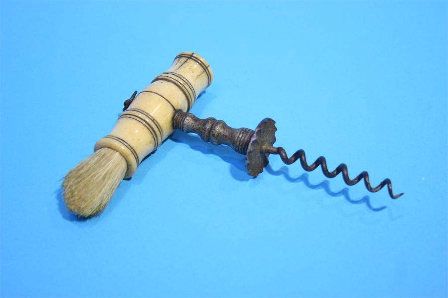 A bone handled corkscrew with brush