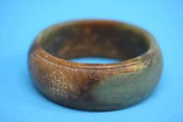 A Jade bracelet with brown inclusions, carved with various motifs, possibly 19th Century or earlier.