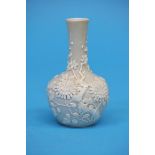 A Chinese bottle vase, 18th/19th Century, decorated in relief with prunus branches. 10 cm high
