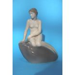 A Royal Copenhagen figure of a mermaid on a rock, printed mark numbered 4431. 21cm height