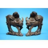 A pair of Oriental carved wood figures of a man riding a water buffalo. 18cm high