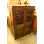 An oak Old Charm style bookcase with leaded glass