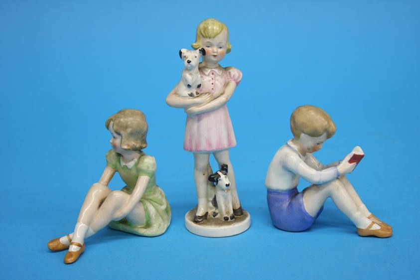 A Goebel figure of a girl holding a dog, GF 83 and two figures of a boy and girl seated