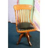 An Edwardian oak revolving desk chair