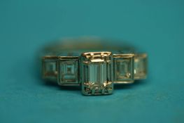 An 18ct white gold and diamond ring, set with central emerald cut diamond flanked by four baguettes,