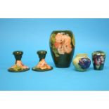 A small squat shaped Moorcroft vase, decorated with 'Pansies', a pair of candlesticks and a vase