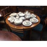 A teak circular dining table and four chairs