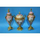 A Continental gilt metal mounted three piece garniture, decorated with panels of landscapes and