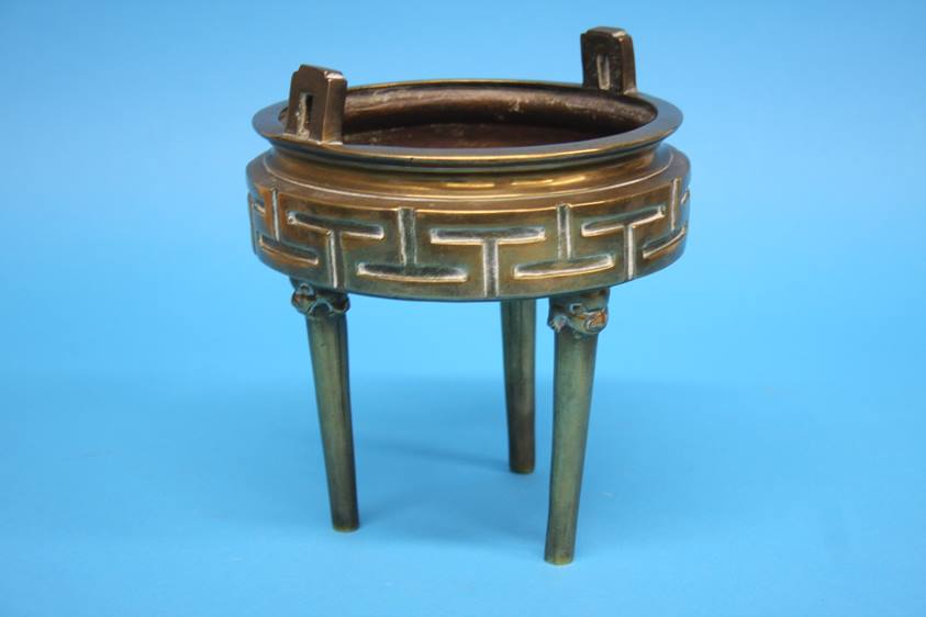 A bronze tripod censer with lion mask terminals and geometric design. 17 cm diameter by 20 cm high