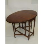 Early 20th century oak drop leaf gate leg table, oval top above turned supports and feet, height