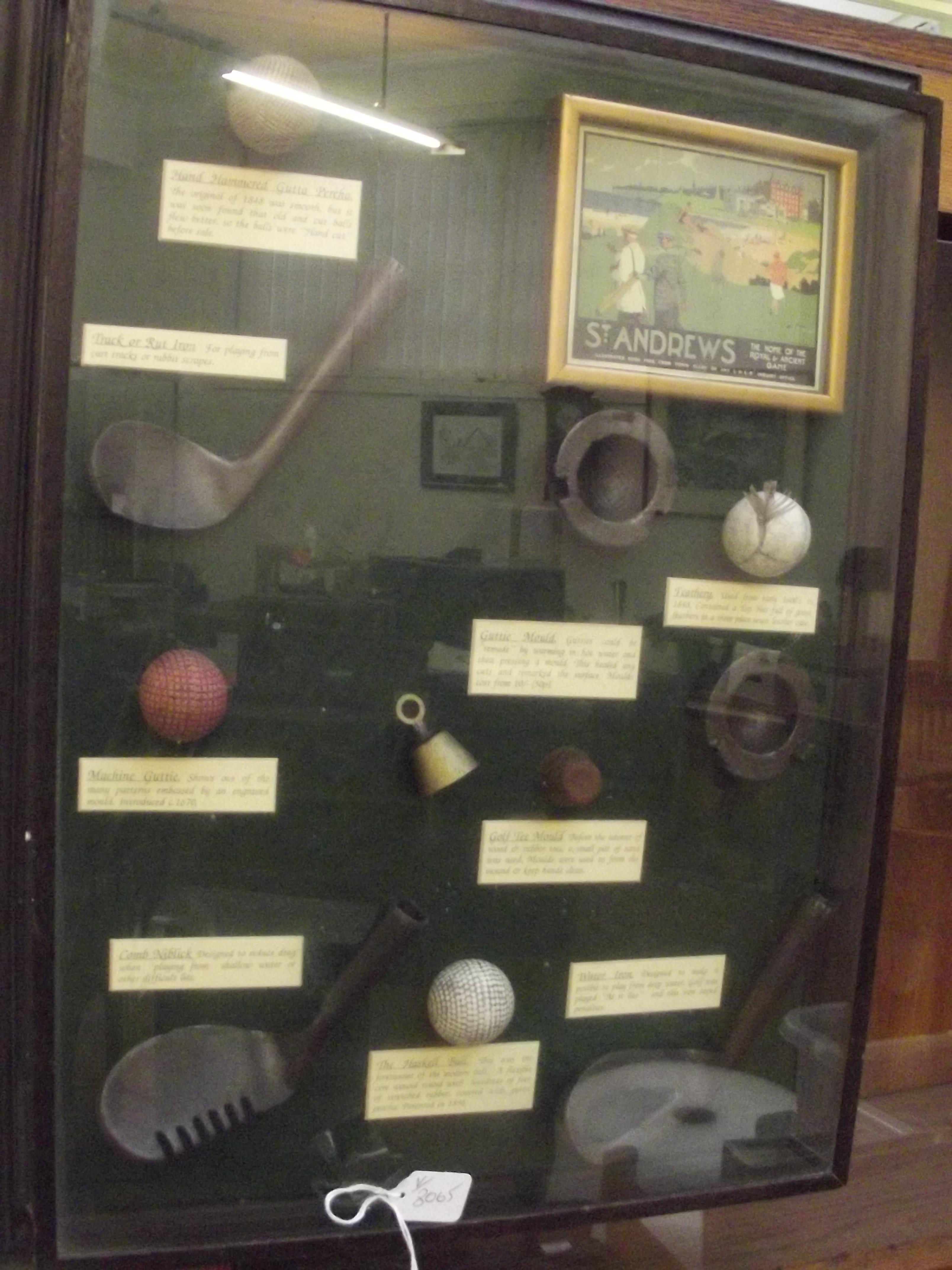 Cased reproduction golf balls and gold clubs