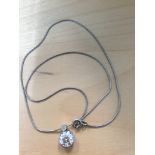 A large diamond pendant on wire chain, set with a smaller diamond to the top of pendant,