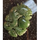 A carved Jade pendant of a coiled Dragon with a heart motif