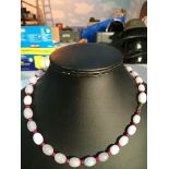 A white jade bead necklace with faceted rubies between beads on an 18ct clasp