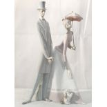 A large Lladro figure of a man and woman with parasol and dog