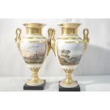 A pair of early 20th century classical style vases with handpainted scenes with mountain & figures