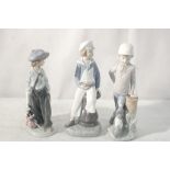 Three Lladro figures of a boy with a yacht,