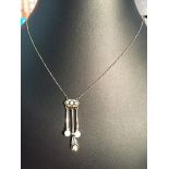 An Edwardian diamond and pearl drop necklace with diamond set pendants,