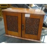 An oak carved smoker's cabinet,