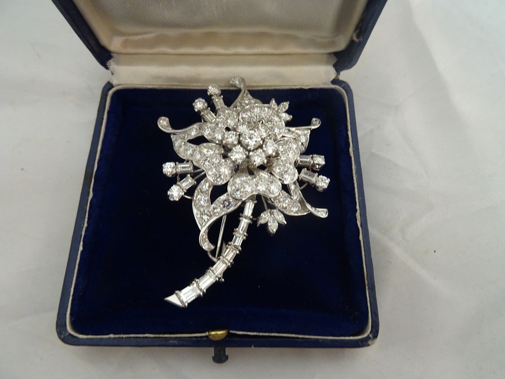 A floral diamond brooch of an aquilegia. Central stone spreads .50ct. Surrounded by 6x .