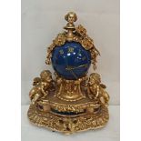 A Victorian style cast metal clock in blue and gilt with cherub decoration