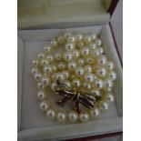 A 9ct bow ruby & diamond clasp pearl necklace, single strand knotted pearl necklace of good colour,