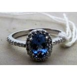 An 18ct (unhallmarked) diamond and oval blue topaz dress ring