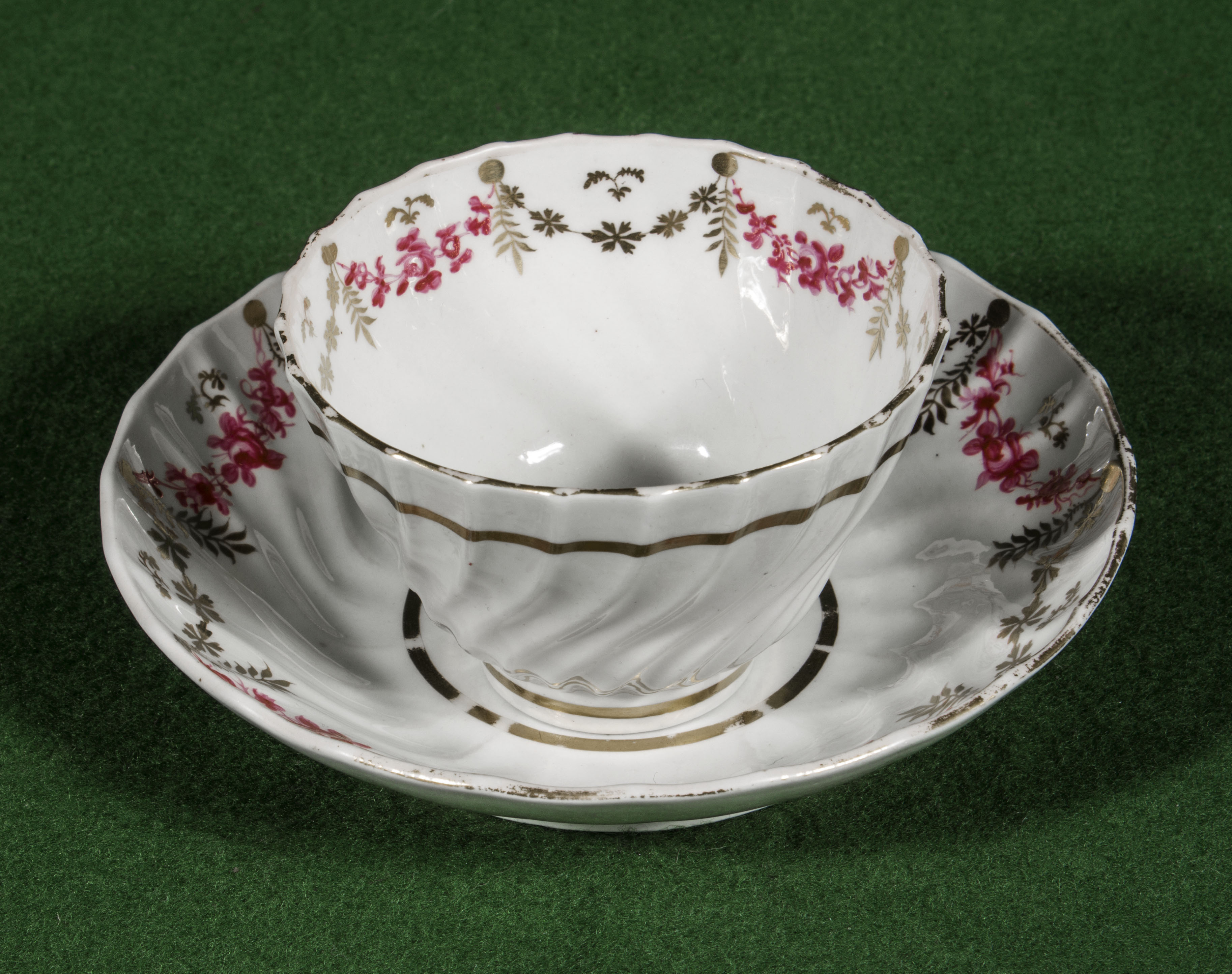 A Worcester tea bowl and saucer with puce and gilt decoration