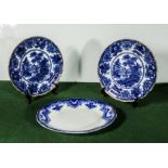 A pair of flow blue plates and an oval serving dish