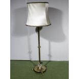 A brass Arts and Crafts style standard lamp and shade