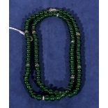 An Art Deco style necklace of green beads with gem set spacers