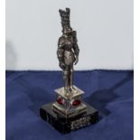 A silver knight with red inset stones on a marble base