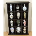 A cabinet containing miniature oriental vases