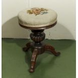 A rosewood piano stool with embroidered upholstery