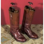 A pair of leather riding boots with stretchers.