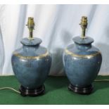 A pair of blue and gilt pottery table lamps