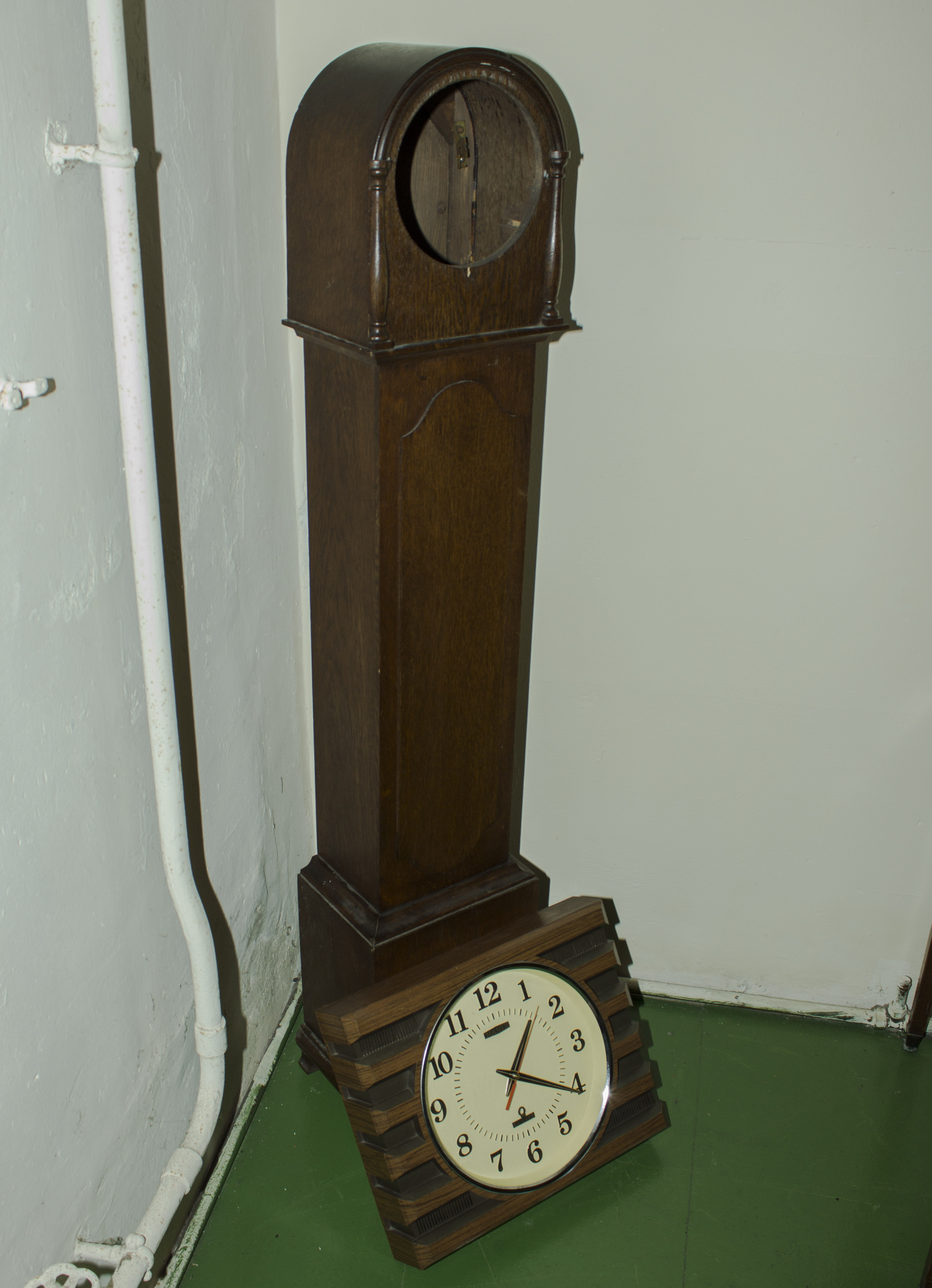 A grandmother clock case together with a modern wall clock