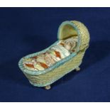 A Staffordshire figure of a baby in a cradle, 13cm long and 5cm wide