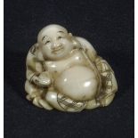 A Japanese ivory netsuke, of a seated Buddha, signed