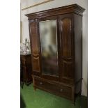 An Edwardian mahogany mirror door wardrobe with drawer base.