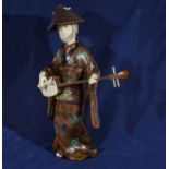 A Japanese ivory and rootwood okimono of a Geisha playing shamisen in traditional dress, Meiji