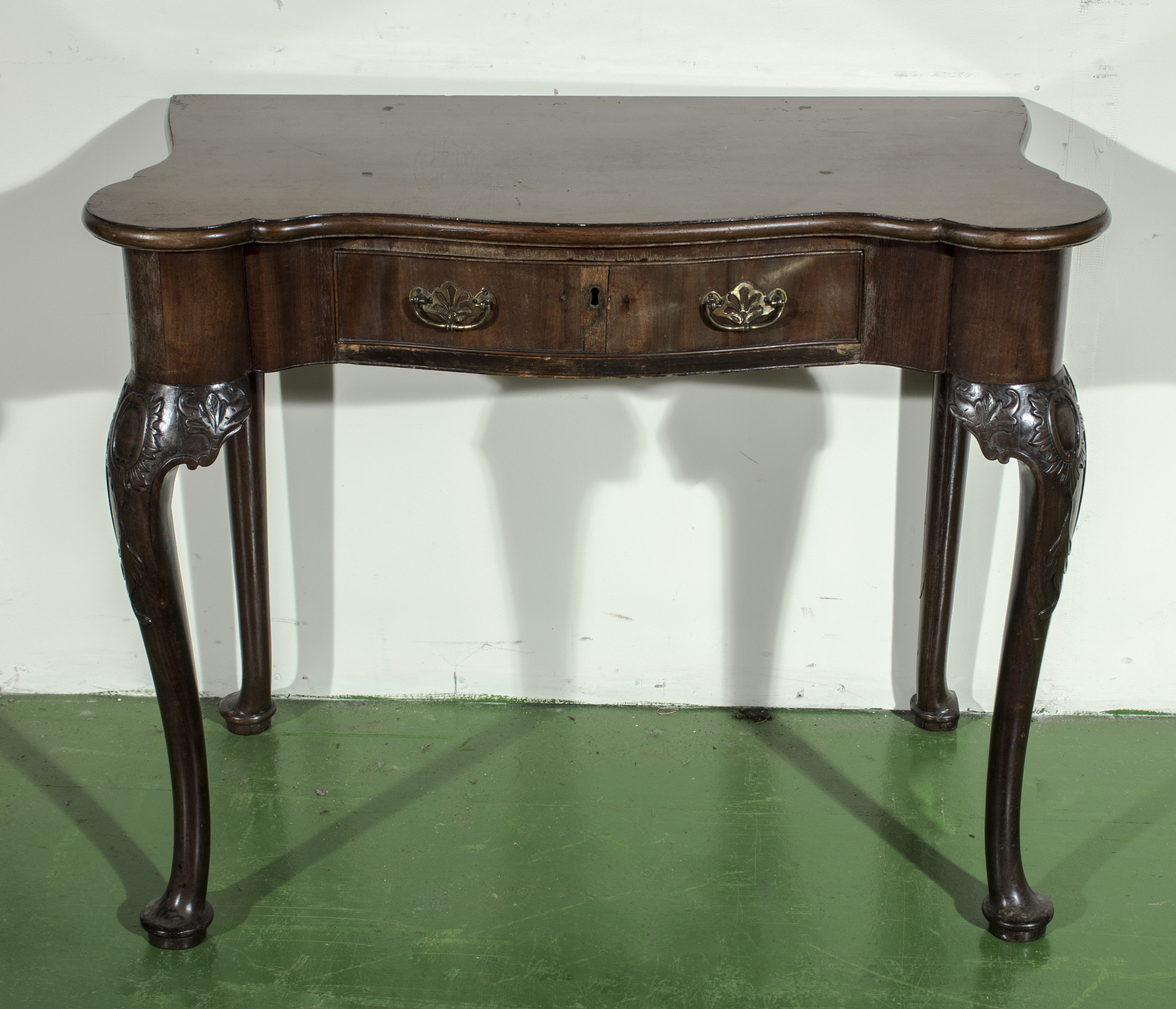 An early George III walnut, adapted side table on carved cabriole legs