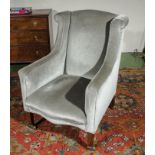 An Edwardian upholstered wing arm chair