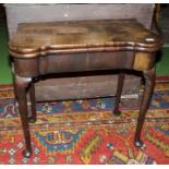 A George I/II walnut tea table with shaped top and pad feet