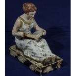 A Staffordshire figure of a girl reading a book by candlelight, circa 1820