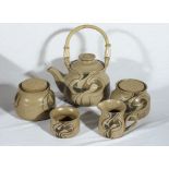 An art pottery teapot, milk and sugar together with two storage jars