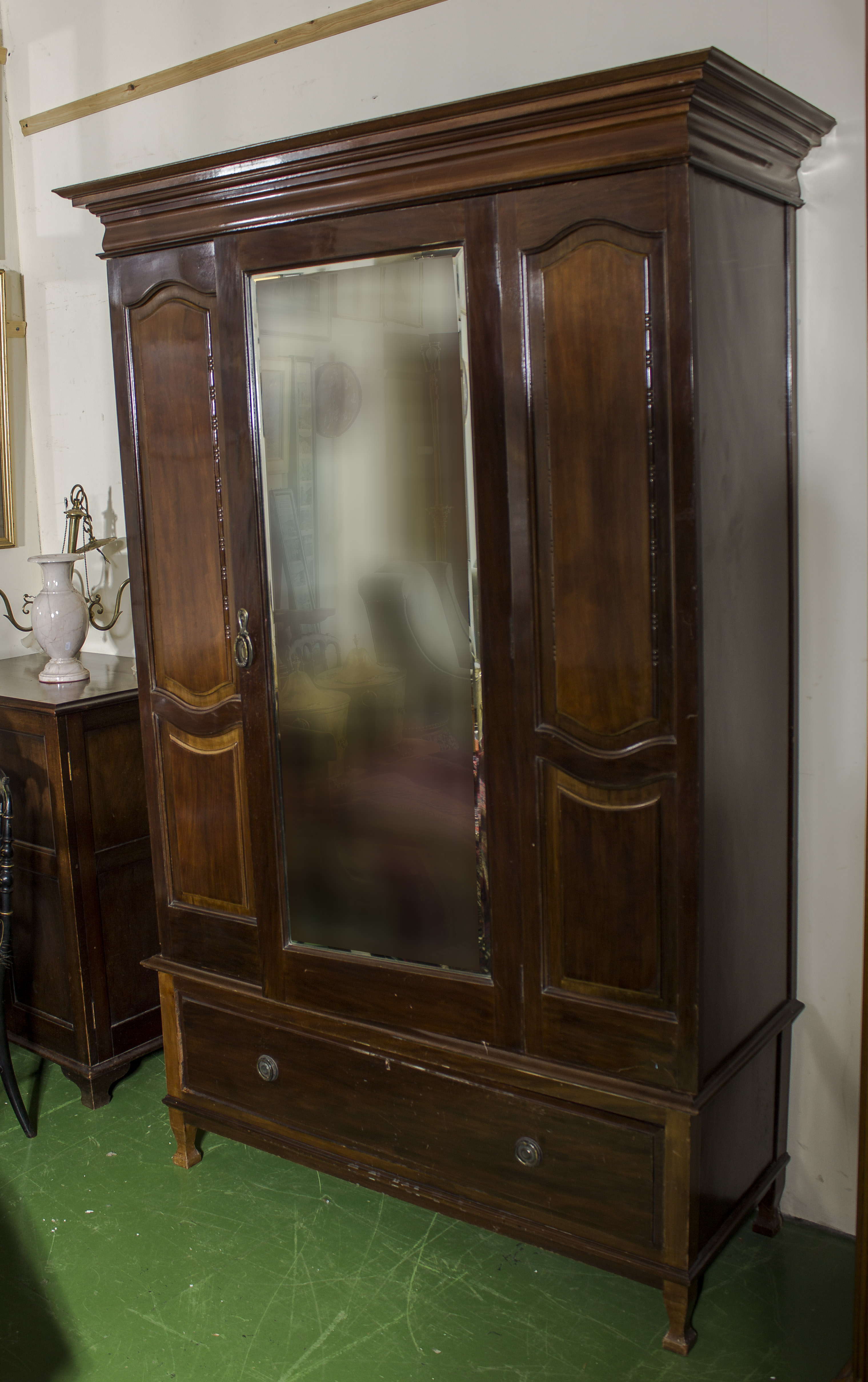 An Edwardian mahogany mirror door wardrobe with drawer base