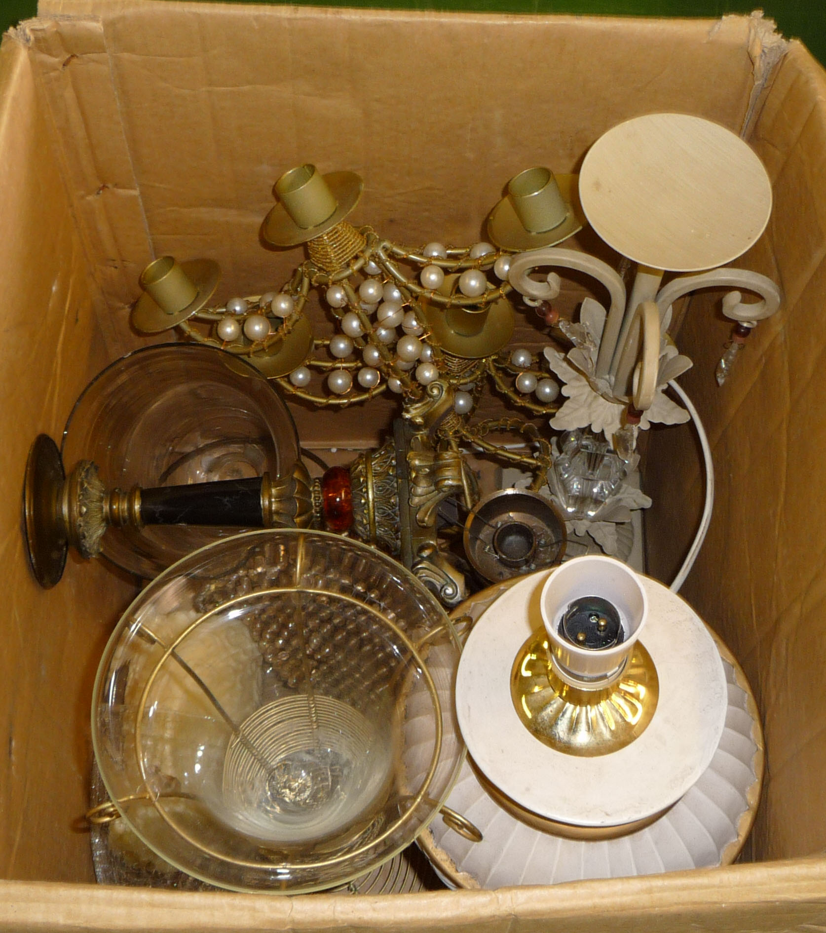 A box containing table lamps and candlesticks