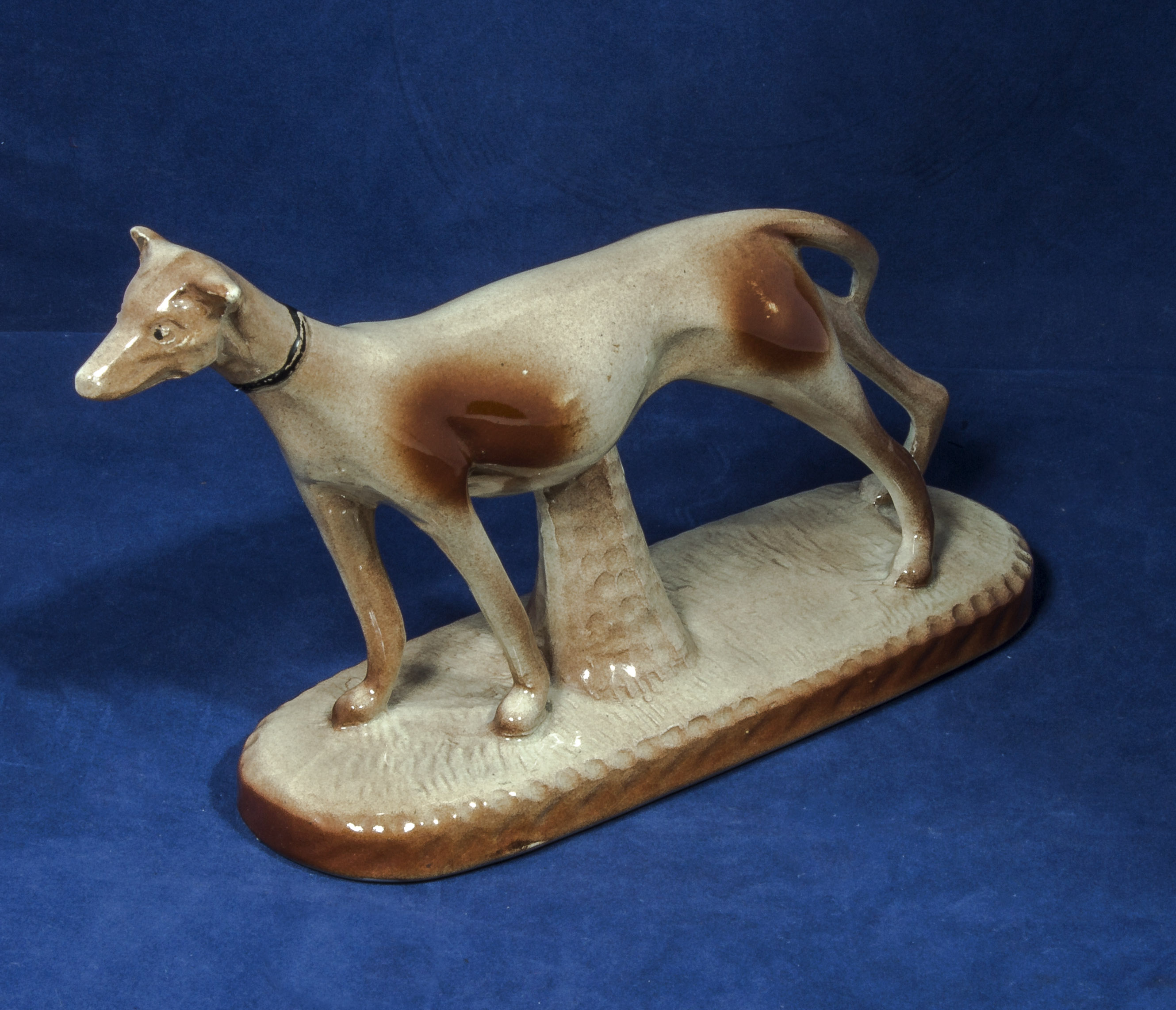 A pottery figure of a greyhound